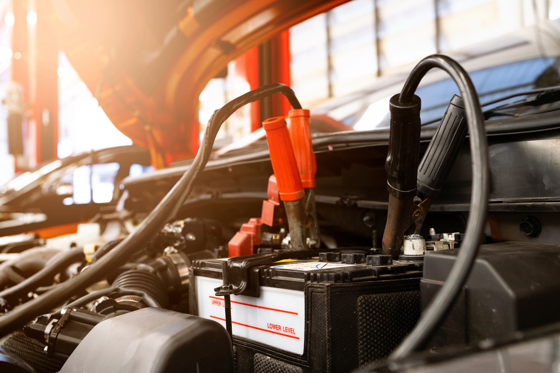 Car Repair Concept. Closeup Charging Car Battery with Electricit